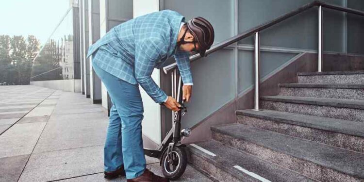man locking scooter image